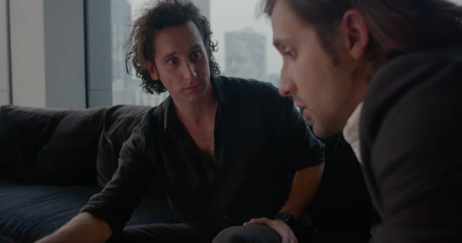 Two males sitting closely having a conversation