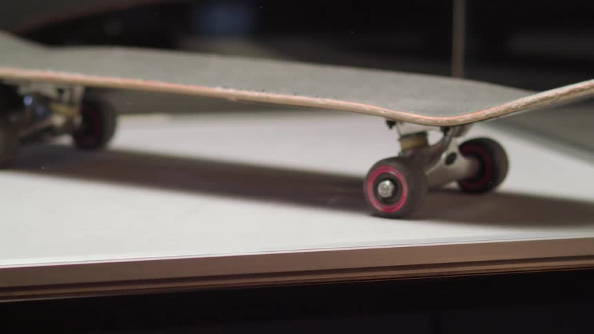 Close up of a vintage skateboard rotating on display in a clear box