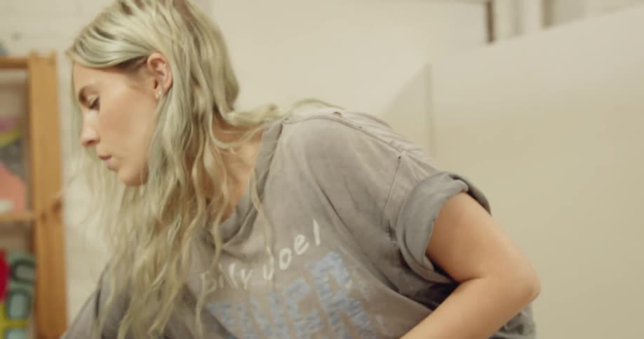 A blonde white woman puts black paint into a cup