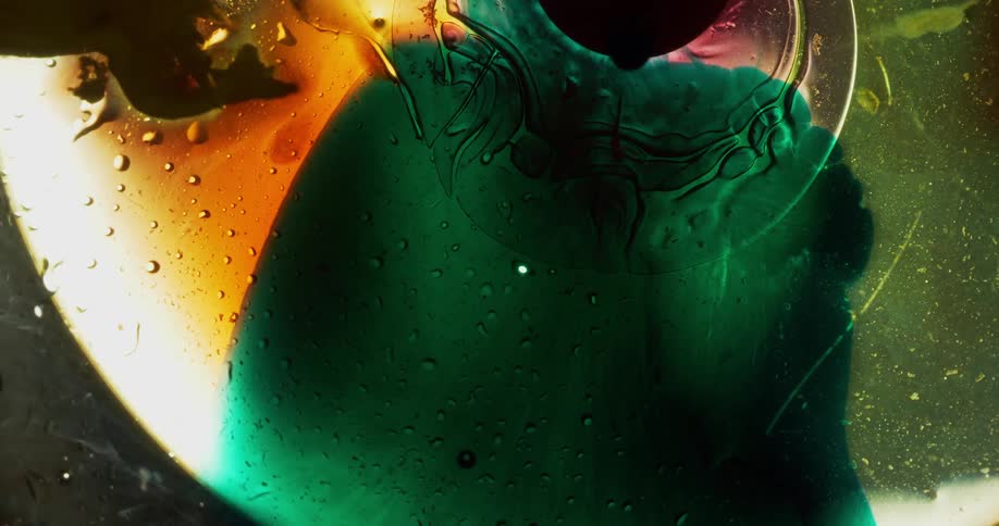 Colored liquid being added to other liquids forming separate shaded bubbles