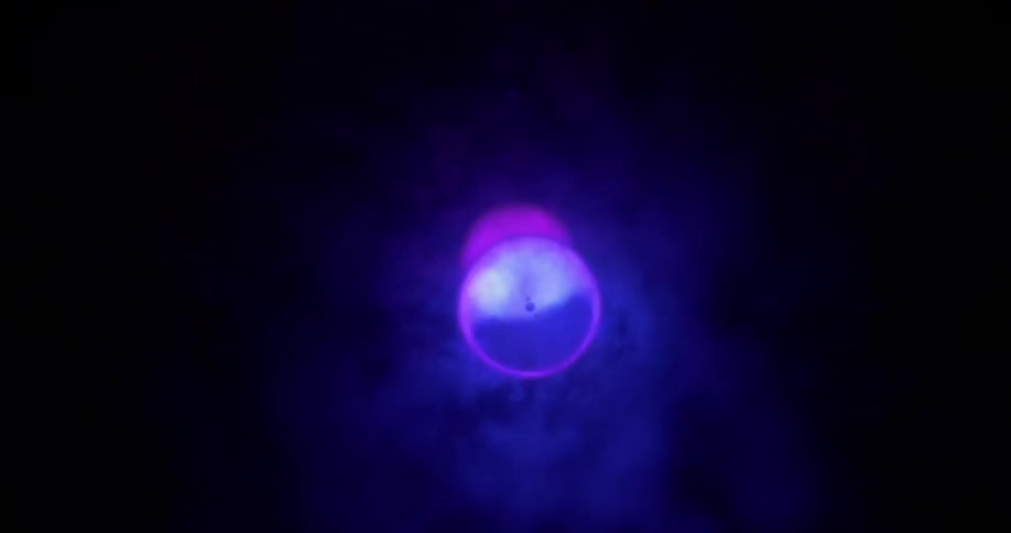A circle of purple light is partially covered by smoke