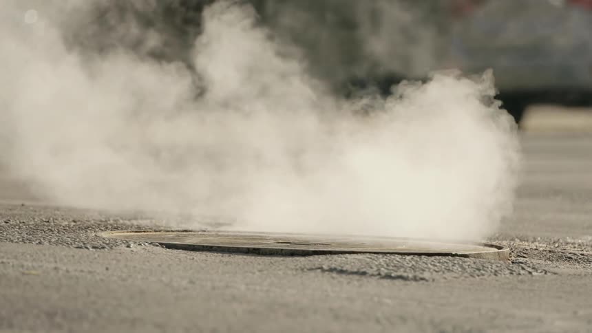 Steam coming out of a manhole in the street