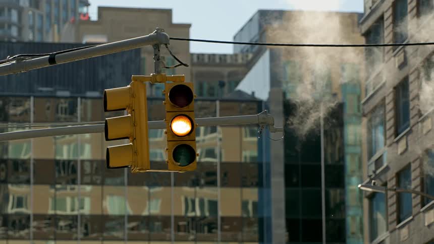A traffic light located in a city area changes from green to yellow and then to red