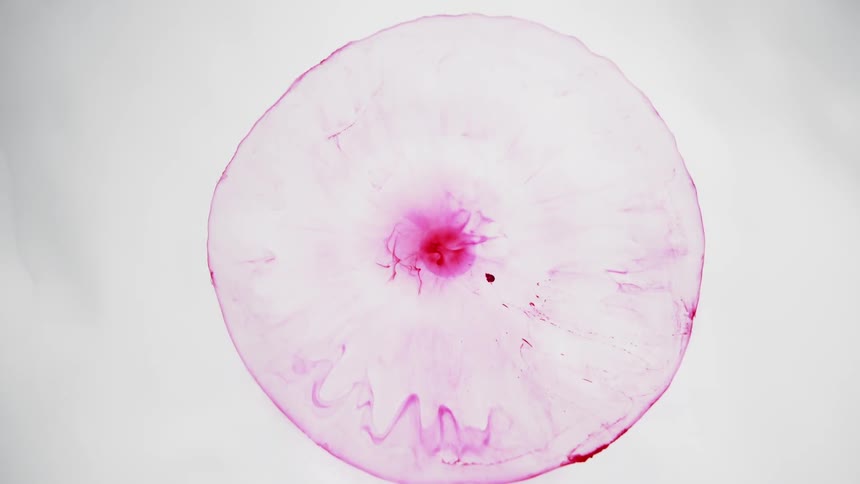 A red liquid flows on a white surface