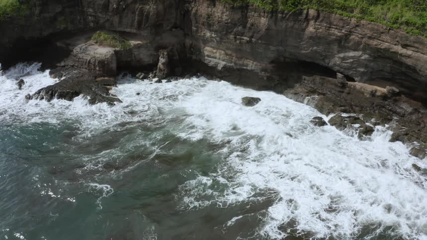 Waves lap the shoreline beneath some cliffs