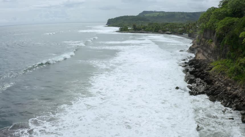 An aerial view of ocean waves moving towards the coast