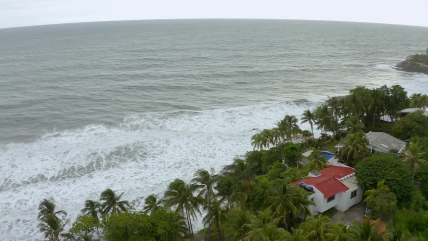 Multiple houses line an ocean front beach