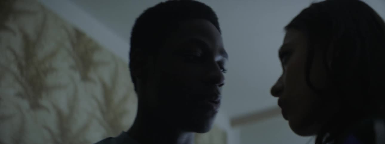 A man and woman talk together in the room