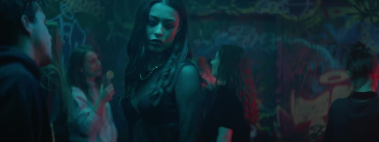 A man and a woman dancing in a nightclub with people in the background