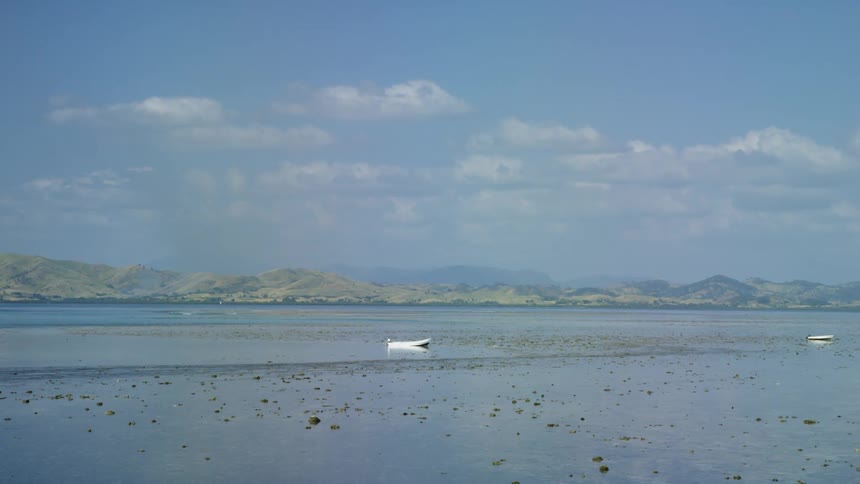 Two white boats sit in shallow water