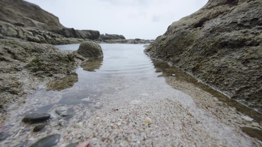 The water slowly moves over the sand and pebbles