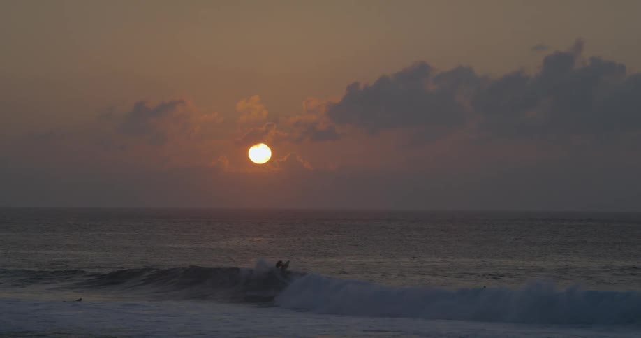 Waves roll towards the shore as the sun sets