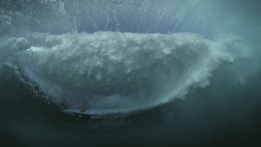 A person surfs a large wave