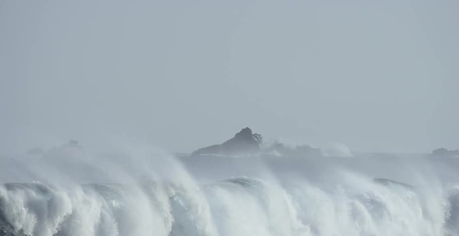 The large waves crash on the shore