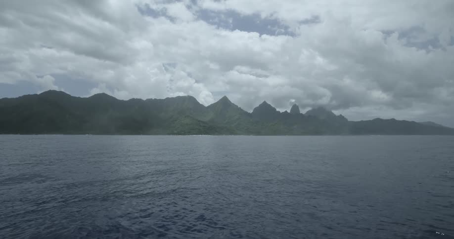 A mountainous coastline is seen in the distance across a serene ocean