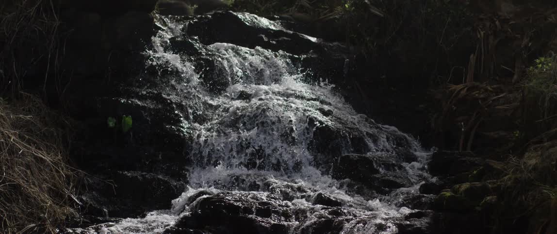 A waterfall tumbles over large rock formations
