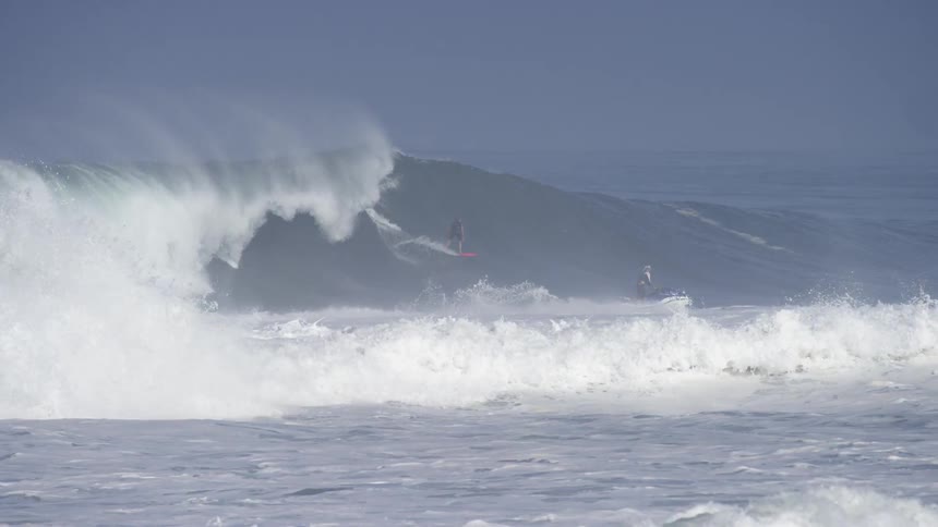 A surfer rides a large cresting wave