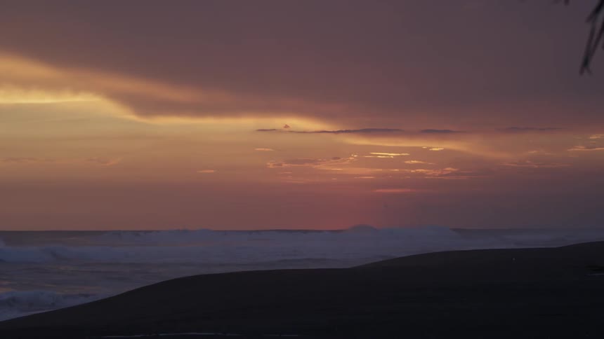 Ocean waves crashing on a shore at sunset