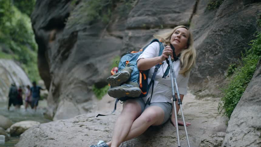 People hike through the water and rock