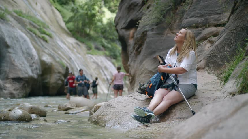 A woman is resting during a hike in the wilderness