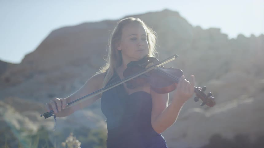 A woman is playing the violin on a sunny day
