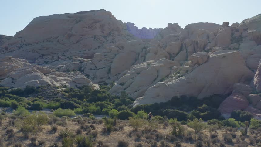 Woman plays violin in front of rugged stone hills