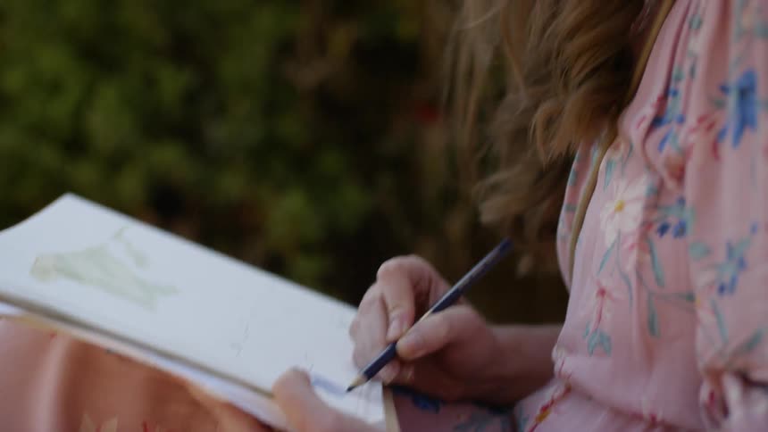 A woman draws outside