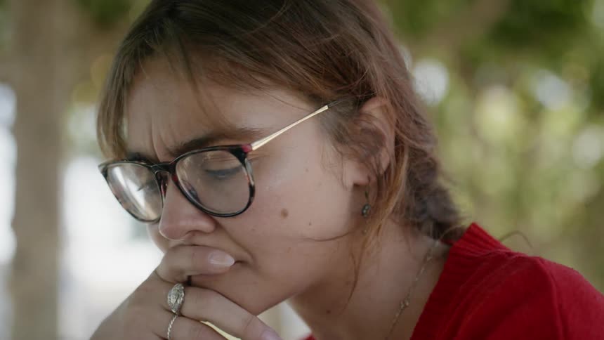 A young woman looks down and thinks