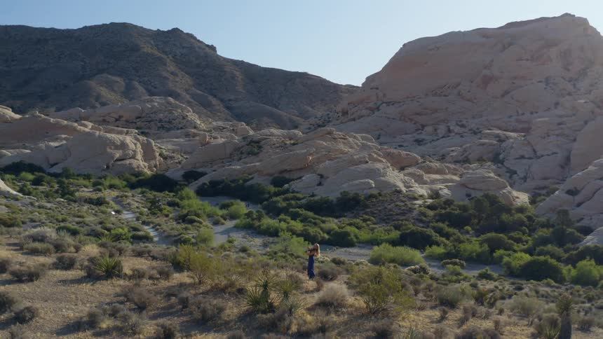 A woman is playing an instrument by a mountain