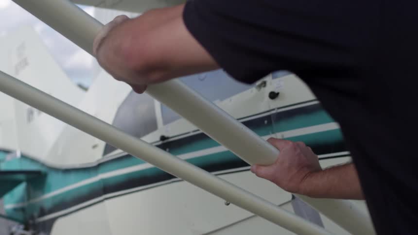 Man leans against a small airplane