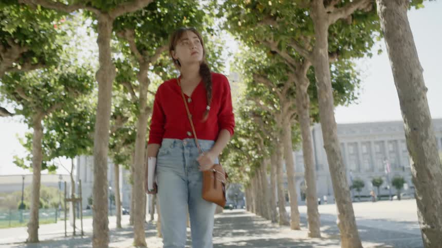 A woman walks down the sidewalk