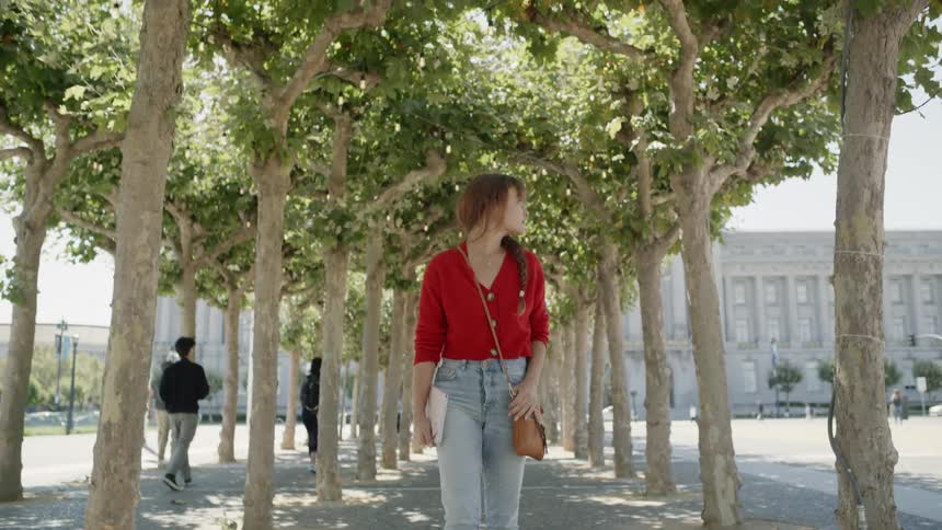 A woman walks down the sidewalk