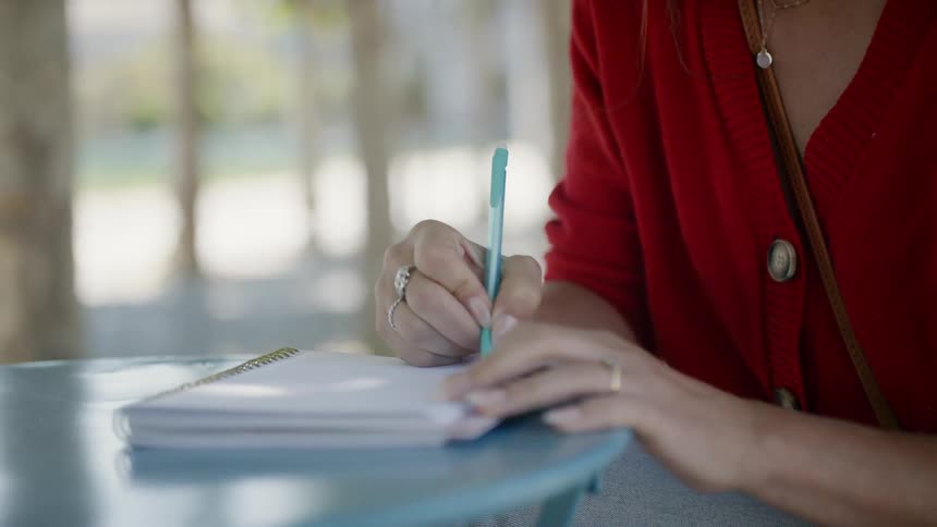 A woman writes in a notebook