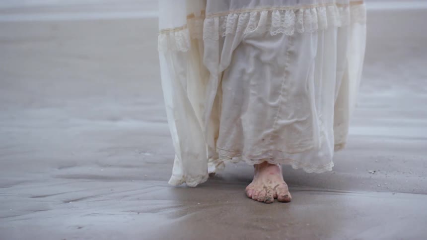 A woman walks across the beach