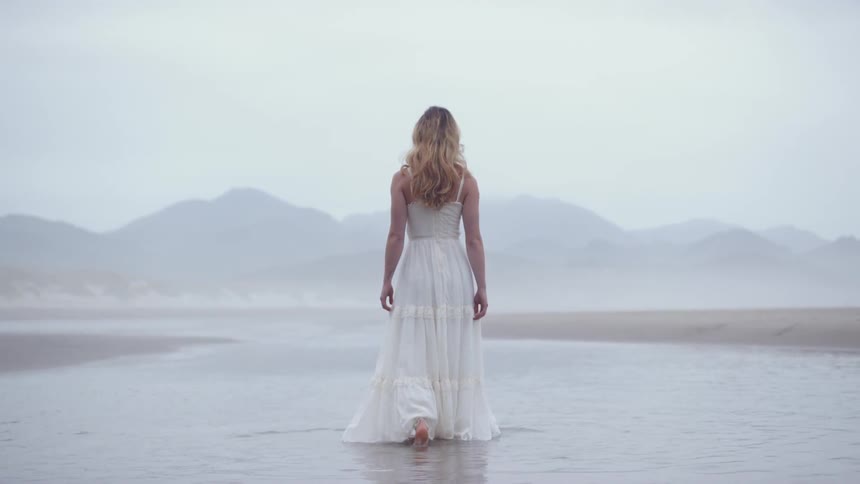 A woman is walking in the shallow water