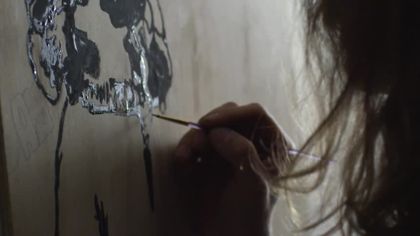 Close shot of a man painting on a canvas