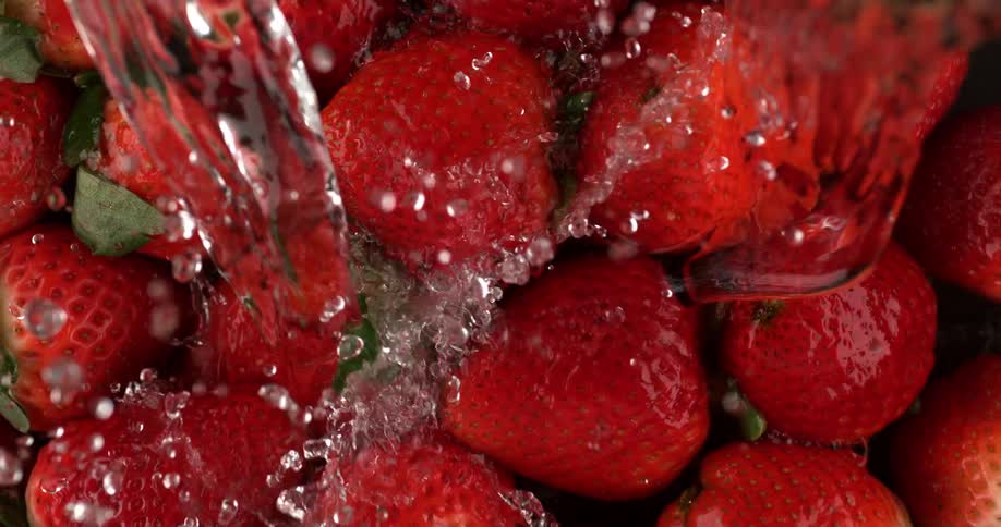 Water is being poured over strawberries