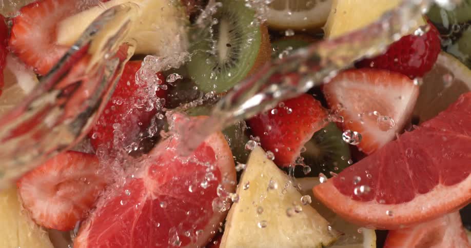 Water being poured over cut up fruit