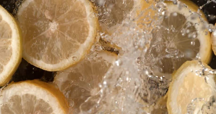 Lemon slices float in water as more water is added