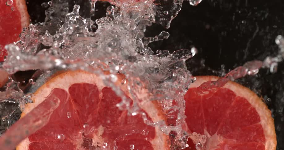 Water being poured onto some sliced grapefruits