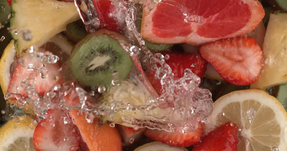 Water is being poured on fresh cut fruit