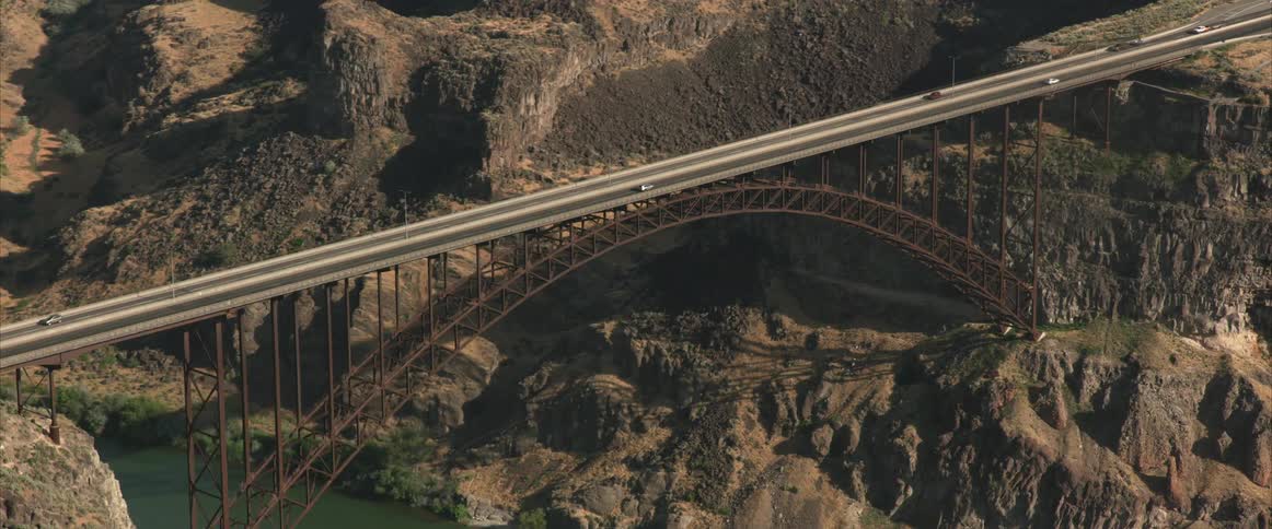 Cars drive over a bridge across a river