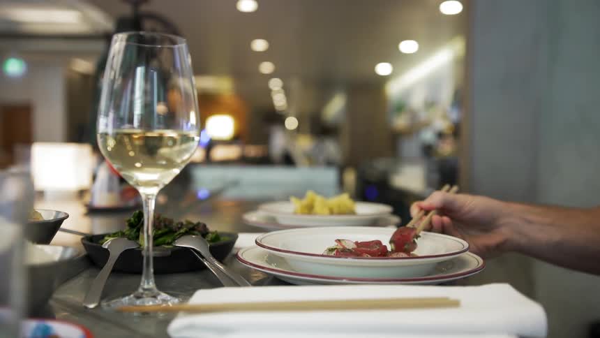 A man using chopsticks to eat in a restaurant