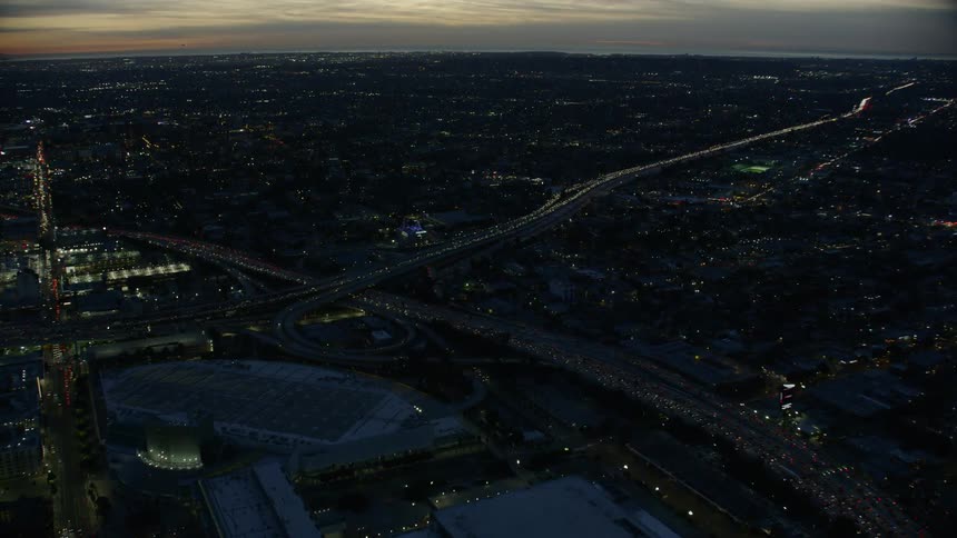 A downtown skyline with arena and stadium during evening rush hour