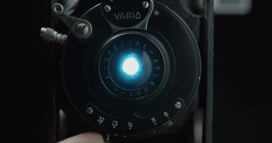 A photographer adjusts the lens of a vintage camera
