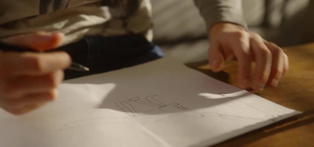A young boy draws a dinosaur