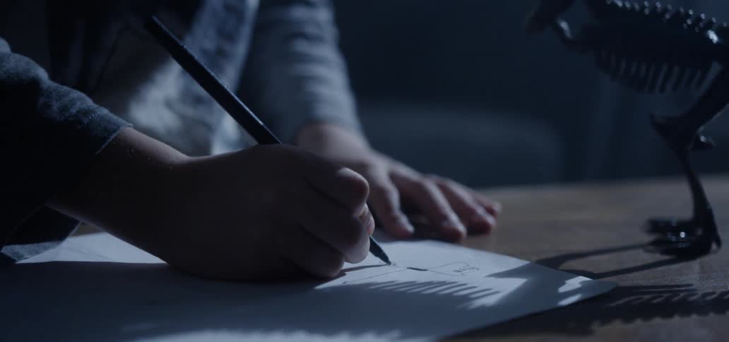 A young boy works on homework at a table