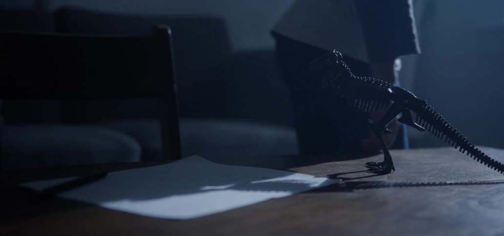 A young boy gets up from doing homework at a coffee table