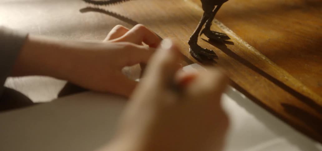 A child draws a dinosaur on a piece of paper