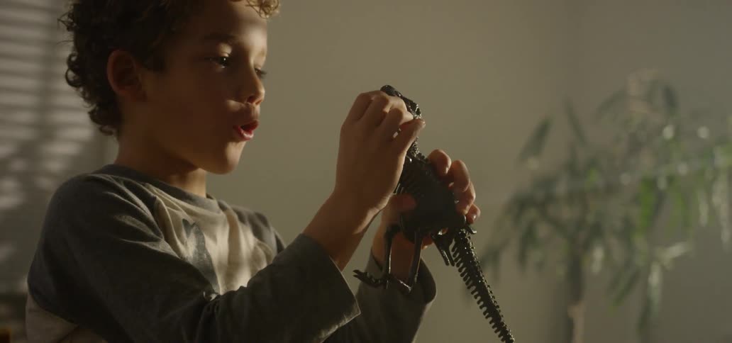 A child plays with a dinosaur skeleton figurine